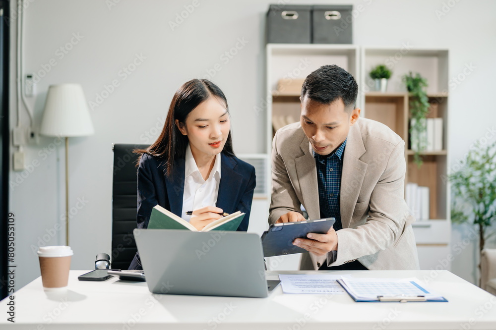 Asian businesswoman and man discuss investment project working and planning strategy with tablet laptop computer Asian businesswoman and man discuss investment project working and planning strategy with tablet laptop computer
