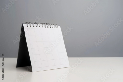 Against a light grey background, a calendar page flips gracefully on a white table, symbolizing the meticulous planning of business schedules and appointments - a visual narrative