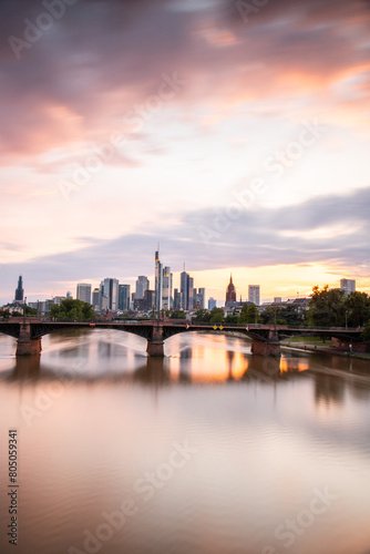 View from a bridge over the River Main to a skyline in the financial district in the background as the sun sets. Twilight in Frankfurt am Main  Hesse Germany