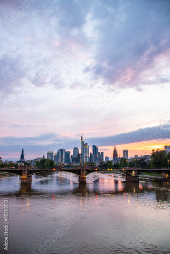 View from a bridge over the River Main to a skyline in the financial district in the background as the sun sets. Twilight in Frankfurt am Main  Hesse Germany