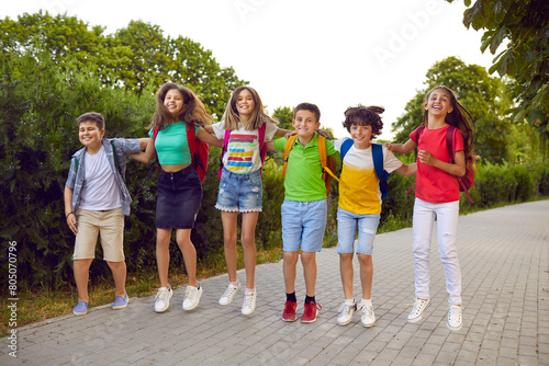 Happy school kids having fun together. Bunch of joyful little school friends playing games outside. Group of cheerful, overjoyed children in comfortable casual clothes jumping on a park path