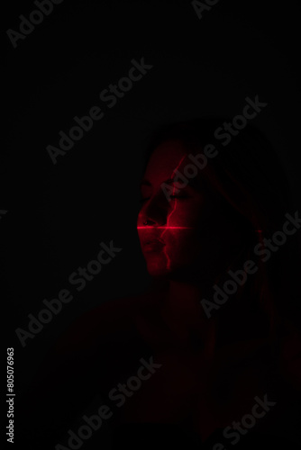 Shine a red laser in the shape of a cross at the girl. Future and virtual reality concept © kanashkin