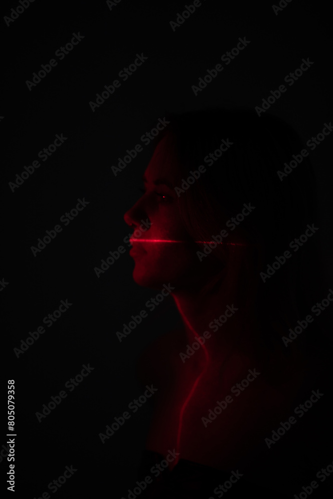 Shine a red laser in the shape of a cross at the girl. Future and virtual reality concept Shine a red laser in the shape of a cross at the girl. Future and virtual reality concept