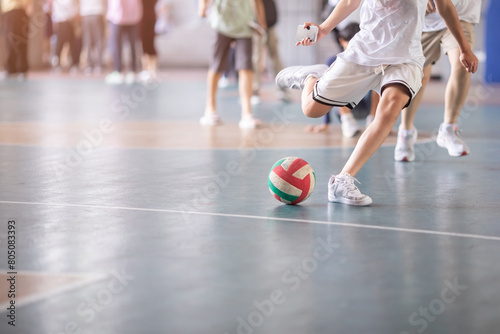 Selective focus to futsal field floor with blurry ball and futsal player.  Futsal player playing ball. photo