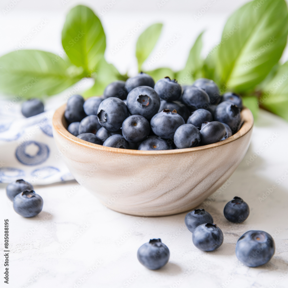 Ripe blueberries in a bowl with green leaves, ideal for healthy eating and culinary themes Ripe blueberries in a bowl with green leaves, ideal for healthy eating and culinary themes