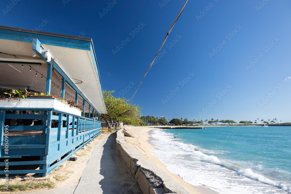 Obraz premium ハワイノースショアのビーチカフェよりビーチの多彩な風景をお楽しみください。朝の穏やかな波音とともに太陽が昇る様子、昼間の活気ある海辺の様子、そして夕焼けに染まる夕暮れの景色。サーファーやシュノーケラー、散歩する人々の様子や、ビーチに広がるパラソルとサンバイザーのカラフルな様子、ビーチ沿いのカフェでのひととき。ワイキキビーチの魅力を凝縮した写真が、リラックスした気分とアロハの心をお届けします。