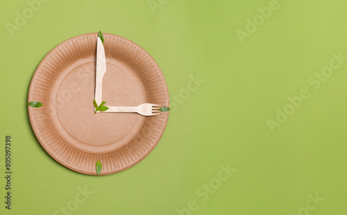 Eco concept. Eco-friendly and sustainable lifestail concept. Clock made of paper plate leaves and wooden fork and knife.