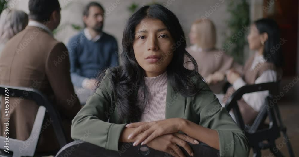 Portrait of pensive Middle Eastern lady sitting at group therapy and looking at camera indoors in rehab clinic. People and psychology concept. Portrait of pensive Middle Eastern lady sitting at group therapy and looking at camera indoors in rehab clinic. People and psychology concept.