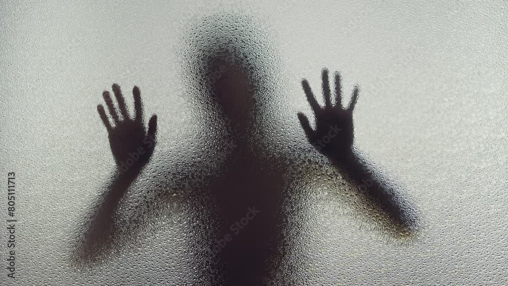 A young woman in pain is screaming behind the frosted glass A young woman in pain is screaming behind the frosted glass