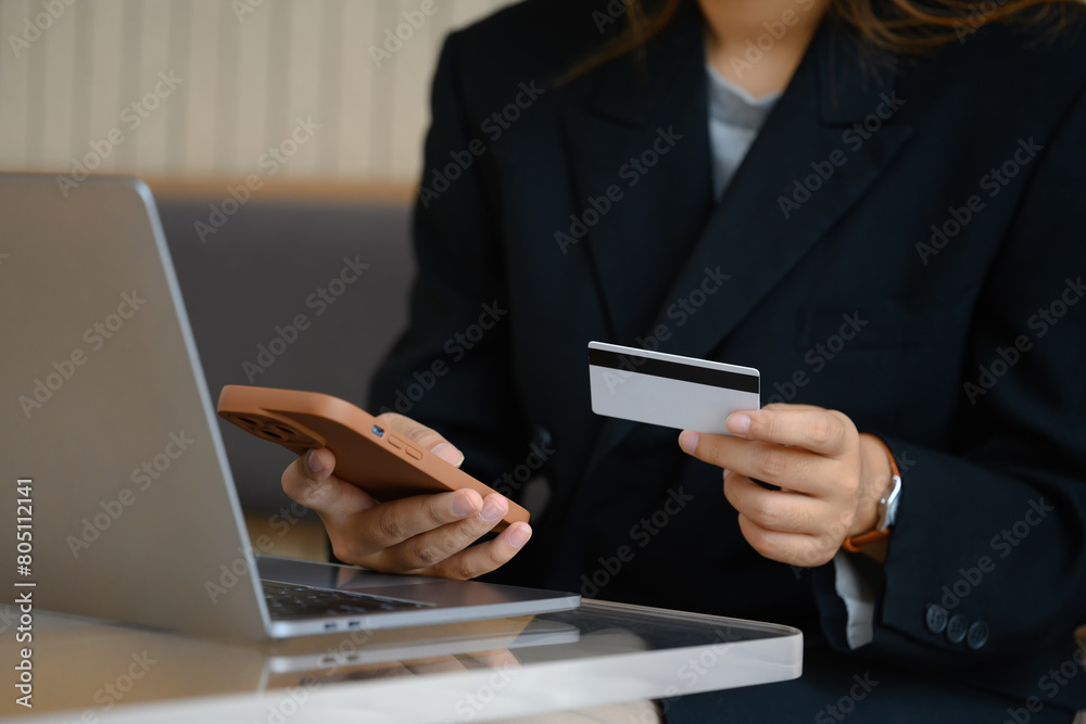 Young businesswoman with credit card doing online shopping on her smartphone Young businesswoman with credit card doing online shopping on her smartphone