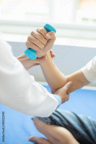 doctor is checking for muscle injuries and using dumbbells test injury and also help with physical therapy strengthen muscles because physical therapy will help strengthen muscles and help blood flow
