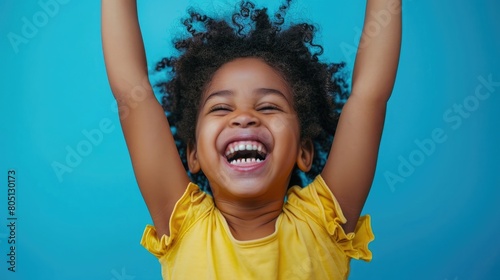 Joyful kid with a 'Smile Day' sign, yellow top and blue backdrop