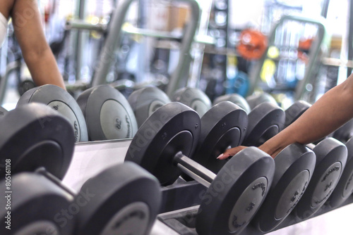 Black woman hand holding a dumbbell at the gym, with copy space