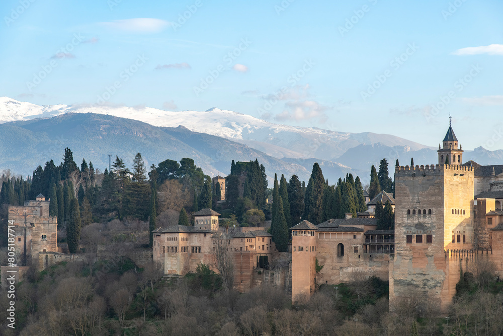High level panoramic sunset view over the Alhambra palace with Islamic and Spanish architecture in Granada, Spain and the snowcapped Sierra Nevada mountains in the background High level panoramic sunset view over the Alhambra palace with Islamic and Spanish architecture in Granada, Spain and the snowcapped Sierra Nevada mountains in the background