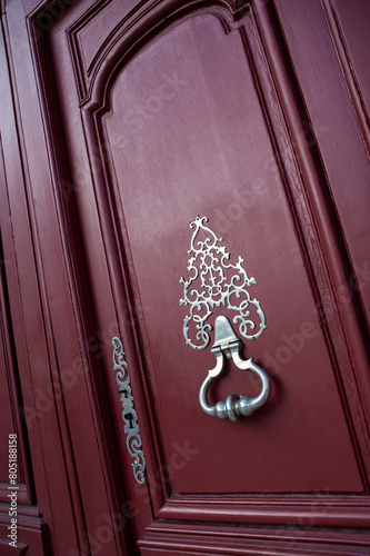 Red wooden door of a classic house in Bordeaux French city © Redzen