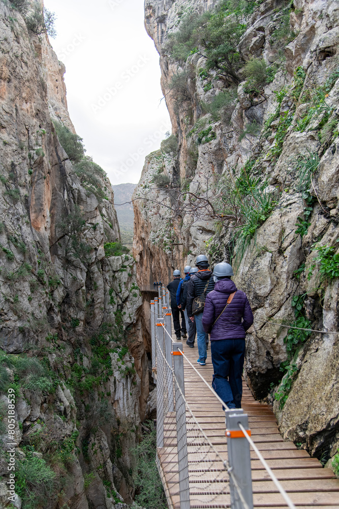 Naklejka premium People walking on pathway of El Caminito del Rey (The King's Little Path) walkway near El Chorro, Malaga, Spain, pinned along the steep walls of a narrow gorge