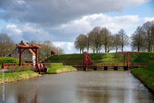 View of canal and rampart with entrance bridges around the village of Bourtange (former Fort Bourtange), near Westerwolde the Netherlands; the fortress was built in 1593 shape of a star  photo