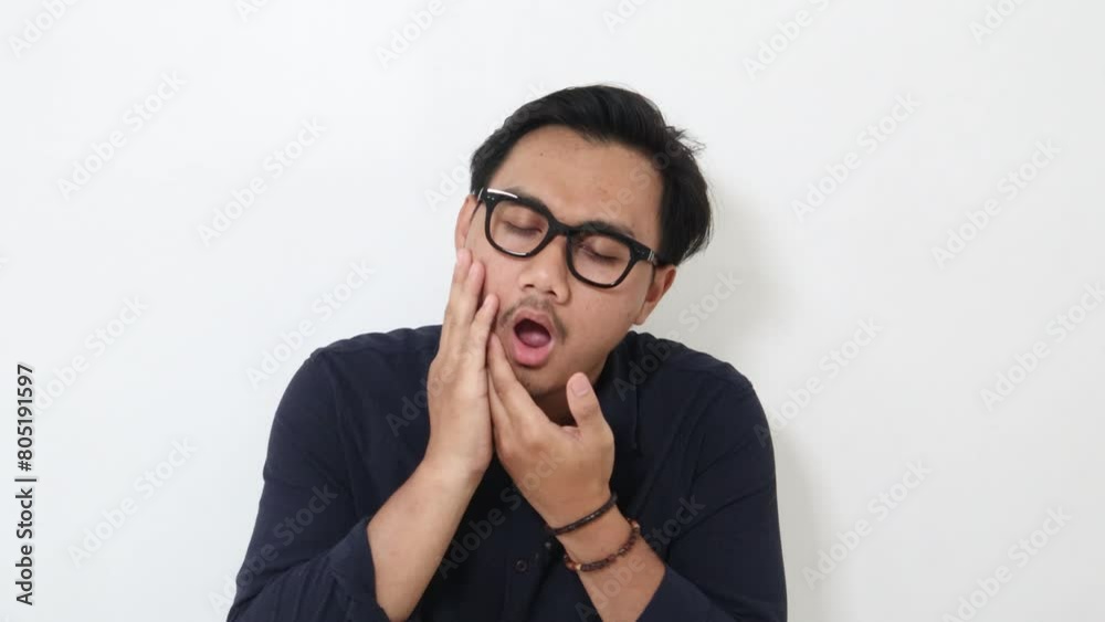 Adult Asian man touching his jaw with pain expression Adult Asian man touching his jaw with pain expression