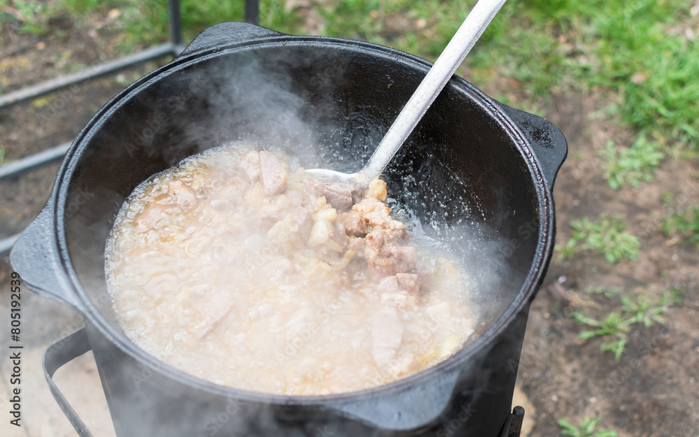 Cooking in a large cauldron in nature Cooking in a large cauldron in nature