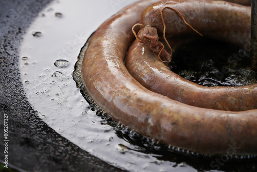 Spicy sausages on a disc fried over an open fire. Traditional Romanian barbecue. Wood fire. Flames of fire.A special culinary experience. The exceptional taste of delicious sausages. 