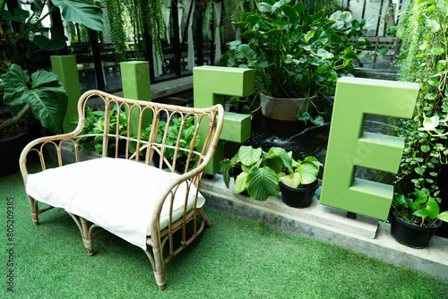 Wooden chairs and soft cushions on the grass amidst shady natural leaves. Outside the garden of the cafe zone photo