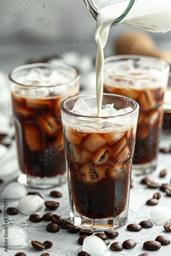 Pouring milk into iced coffee on a bright tabletop creating a refreshing and energizing drink