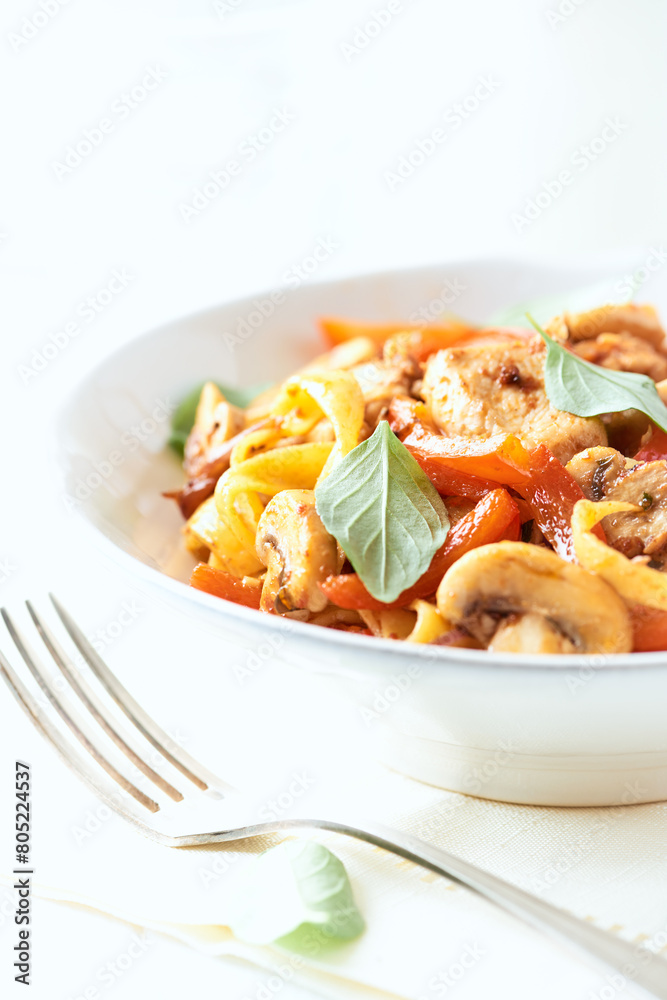 Pappardelle Pasta with chicken breast, red pepper and champignons. Bright background. Close up.	