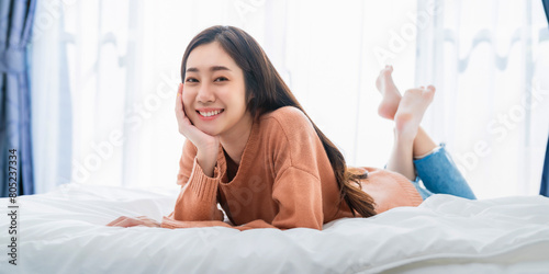 Young Asian woman sleeping in the bed and relaxing in the holiday.
