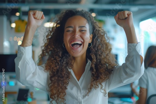 Young beautiful woman with curly hair inside office celebrating victory success