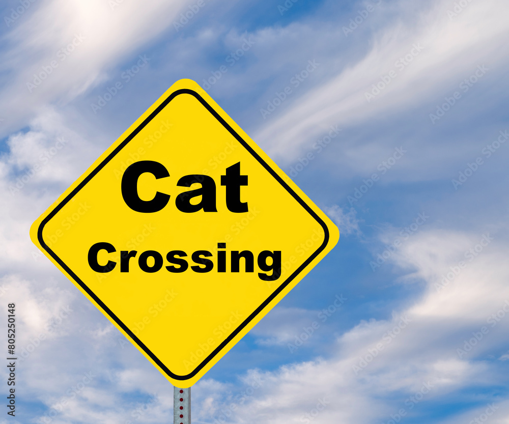 Yellow Diamond shaped warning road sign, Cat Crossing, against a cloudy blue sky with copy space. Yellow Diamond shaped warning road sign, Cat Crossing, against a cloudy blue sky with copy space.
