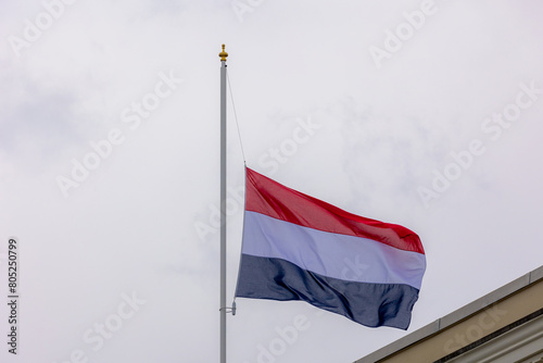 04 May every year, Remembrance of the Dead (Nationale Dodenherdenking) National flag of the Netherlands with half-mast, Memorial to victims of the world war two, Dutch flag hanging outside building.
