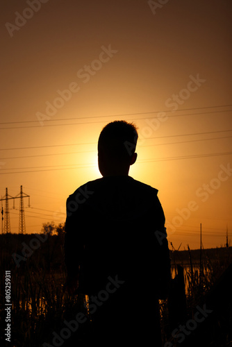 Silhouette of a little boy against a beautiful sunset