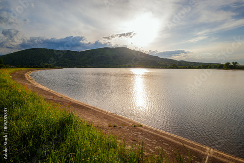 Sunset over Lake Czanieckie in Porąbka. Spring in the Beskid Mały Mountains. The bridge in the distance. A fragment of the blue tourist trail