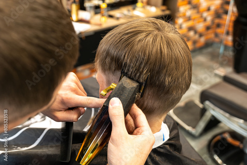 Pleasant professional barber using haircutting machine © BUCSA