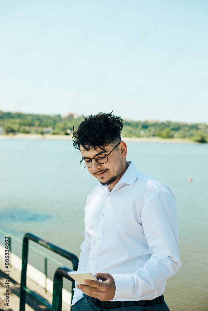 Young businessman.
Portrait of a young handsome businessman using his mobile phone outdoors
