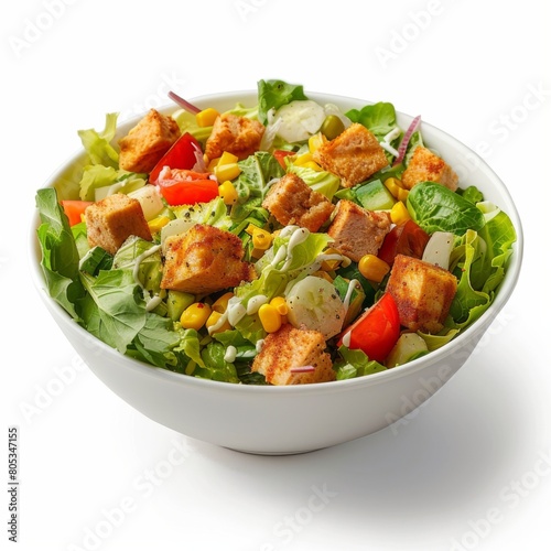 A white bowl filled with salad and covered in tofu