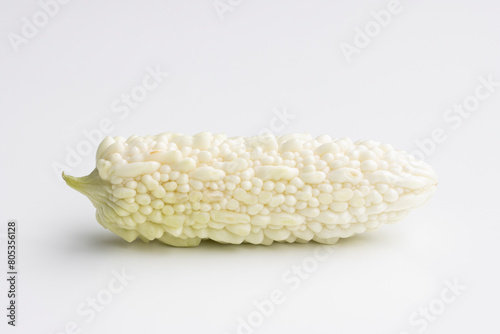 A fresh white bitter melon isolated on a white background. Bitter melon (Momordica charantia) is a tropical and subtropical vine of the family Cucurbitaceae grown for its edible fruit.