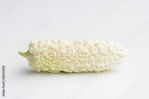 A fresh white bitter melon isolated on a white background. Bitter melon (Momordica charantia) is a tropical and subtropical vine of the family Cucurbitaceae grown for its edible fruit. photo