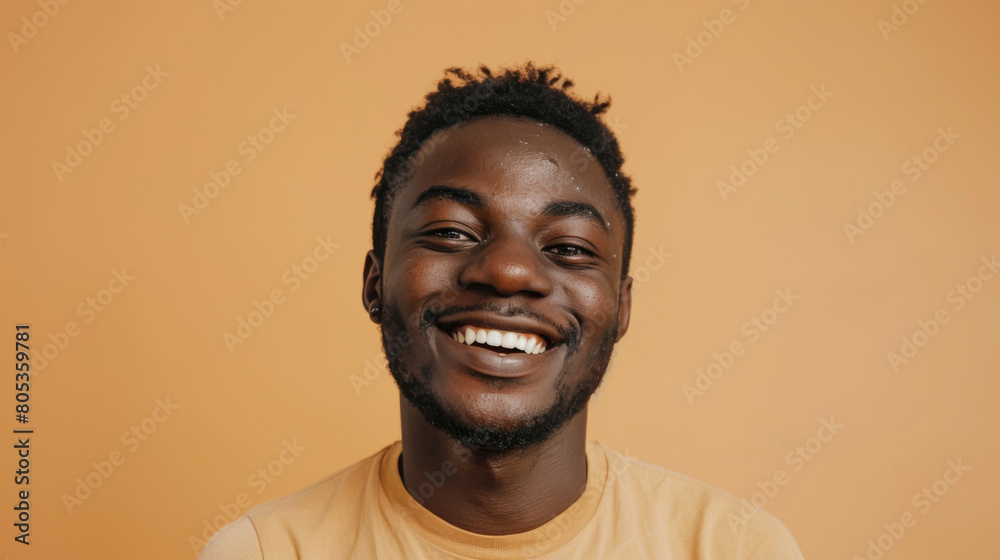A man with a big smile on his face is wearing a yellow shirt