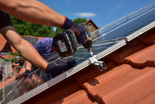 Tableau sur toile Dachdecker beim Aufbau einer Photovoltaikanlage auf einem neu gedeckten Ziegelda