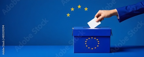 A hand placing a ballot into a blue ballot box with the European Union flag on it, Voting for the European Union election © nizar