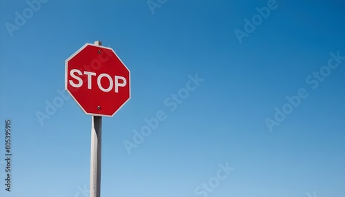 A red stop sign against a clear blue sky