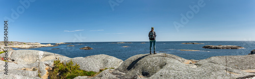 Frau mit Rucksack an der Schärenküste in Südnorwegen