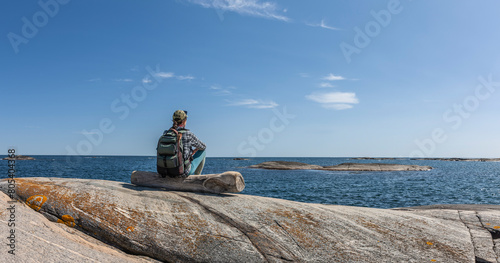 Frau mit Rucksack an der Schärenküste in Südnorwegen