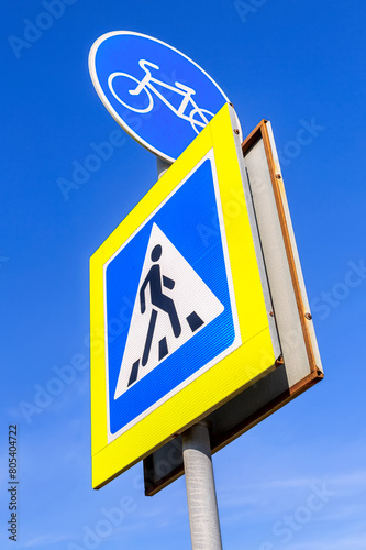 Bicycle road sign for bikes lane and pedestrian crossing sign against the sky