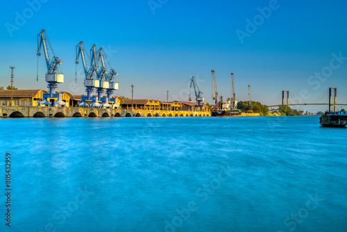 фотографія Single jib portal cranes, facilities of the river port of Seville, Spain
