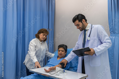 Doctor Visiting Patient On Ward. Hospitalized man lying in bed while doctor checking his. physician examining patient in hospital room. Hospital Ward