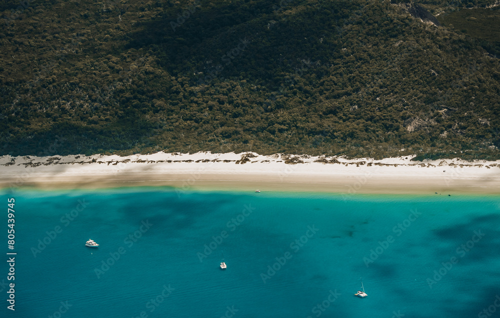 Whitehaven beach with a sailing boat in the foreground