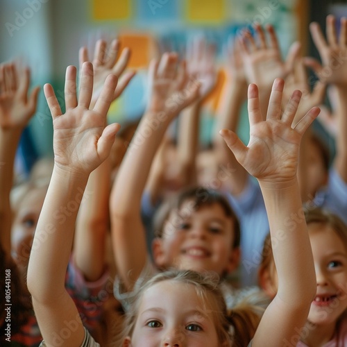 Children hands raised in a classroom with many friends