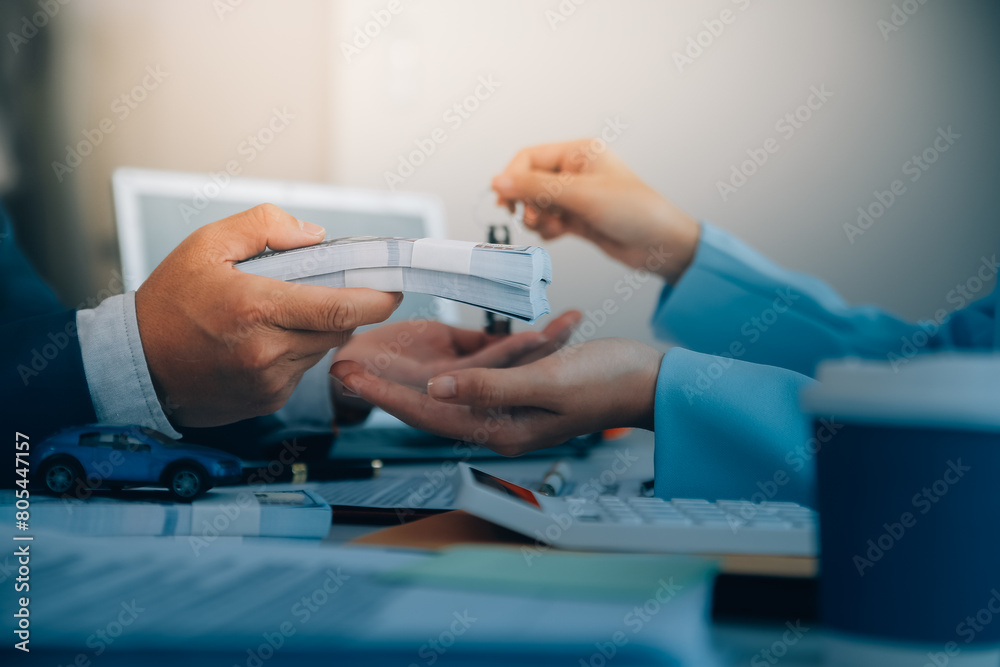 Fototapeta premium Insurance officers hand over the car keys after the tenant. have signed an auto insurance document or a lease or agreement document Buying or selling a new or used car with a car